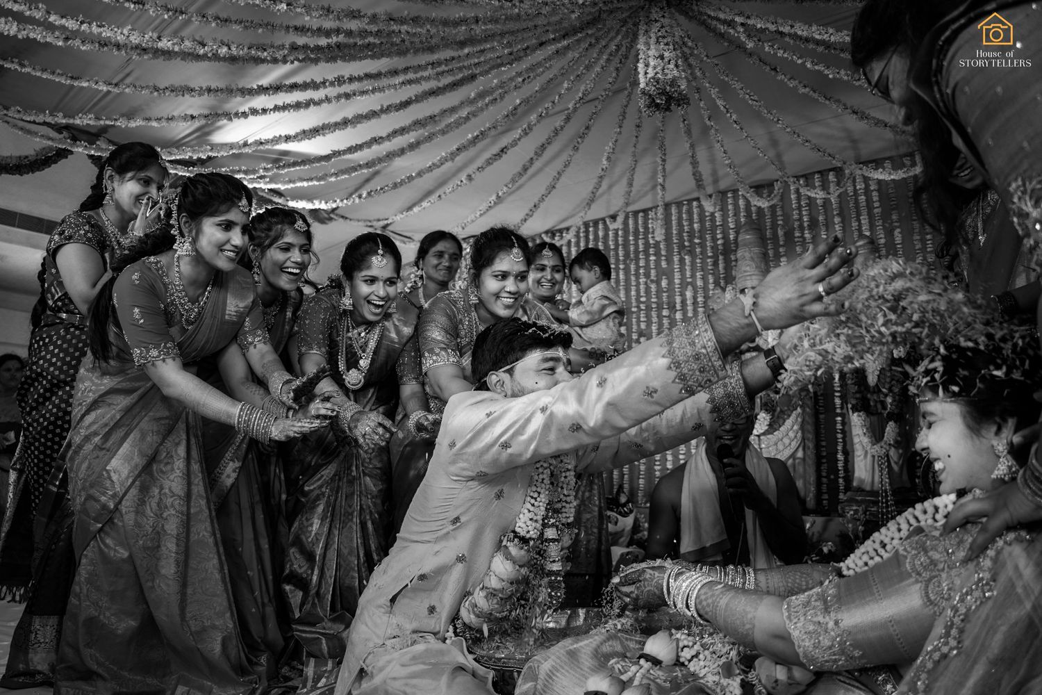 A traditional Indian wedding ceremony moment with guests gathered under a decorated tent.