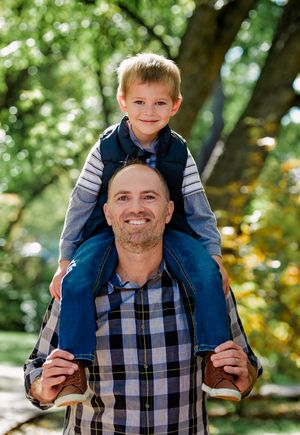 Playful outdoor family photography sequence showing a father giving his child a piggyback ride in a park setting.
