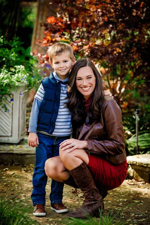 A heartwarming outdoor autumn photoshoot with rich fall colors and foliage in the background.