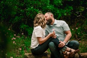 Romantic couple sitting together in a lush green garden setting sharing intimate moments.