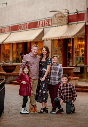 Family poses together in front of vintage storefronts at sunset, creating a charming downtown scene.