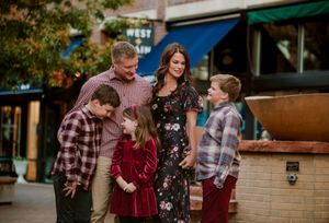 A family enjoying a playful moment together outdoors during a casual photo session.