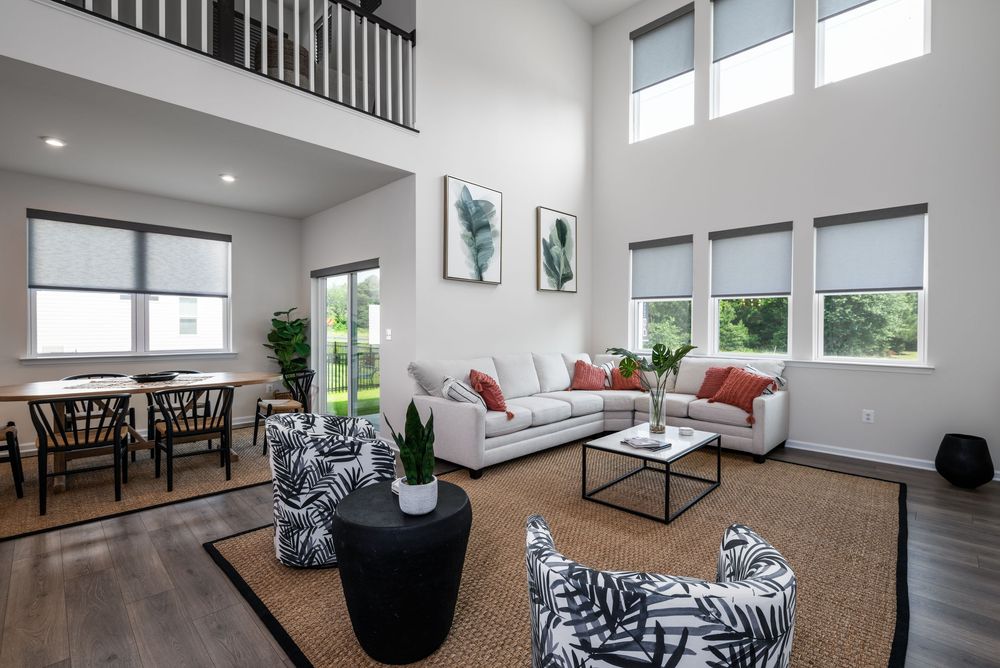 Modern two-story home interior showcases an open concept living space with high ceilings and abundant natural light.