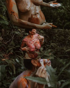 Artistic outdoor photo series showing a couple covered in colorful paint embracing in a moody forest setting.