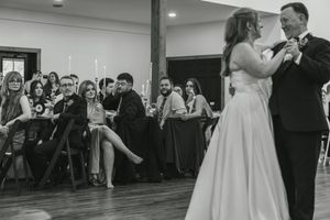 Wedding reception dance floor filled with guests celebrating and dancing under indoor lighting.
