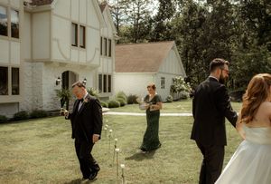 Outdoor wedding first look sequence with church building in background.