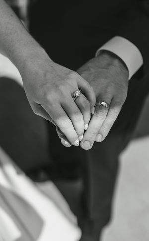 Close-up black and white shots showing hands with wedding rings in various poses and angles.
