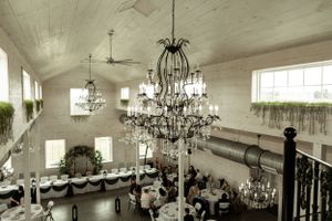 Vintage-style reception hall with elegant chandeliers and white decor.