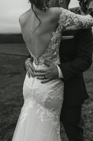 Black and white detail shot of lace wedding dress with open back design.