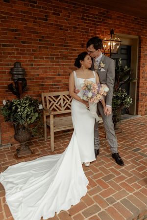 White wedding dress flowing across brick patio during romantic shoot.