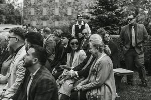 Several people gathered outdoors in what appears to be a casual social setting in this black and white photograph.