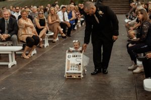 Wedding ceremony detail with aisle signage and seated guests.