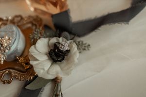 Closeup of wedding accessories with vintage gold frame and white floral details.