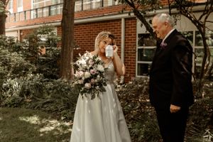 A beautiful emotional moment with a white floral bouquet in a garden setting.
