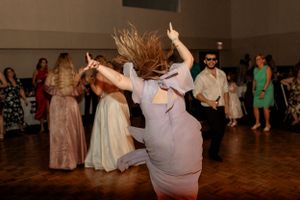 Energetic dancing and celebrations at a wedding reception with guests in formal attire.