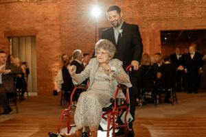 Heartwarming dance moment captured in warm lighting at brick-walled reception venue.