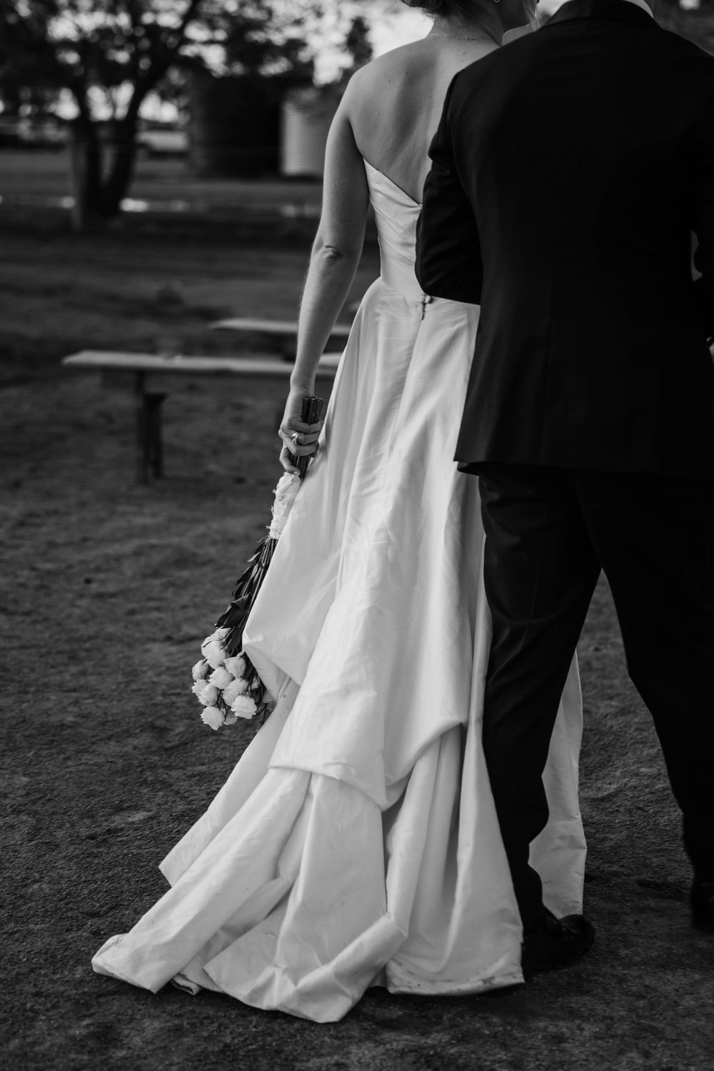 Black and white portrait of couple in formal attire from behind.