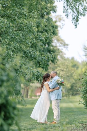 Children share a sweet moment together in a lush green park setting during a summer photoshoot.