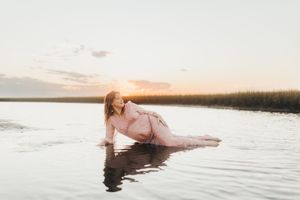 A person floats serenely in calm water during sunset, creating a peaceful and ethereal scene.