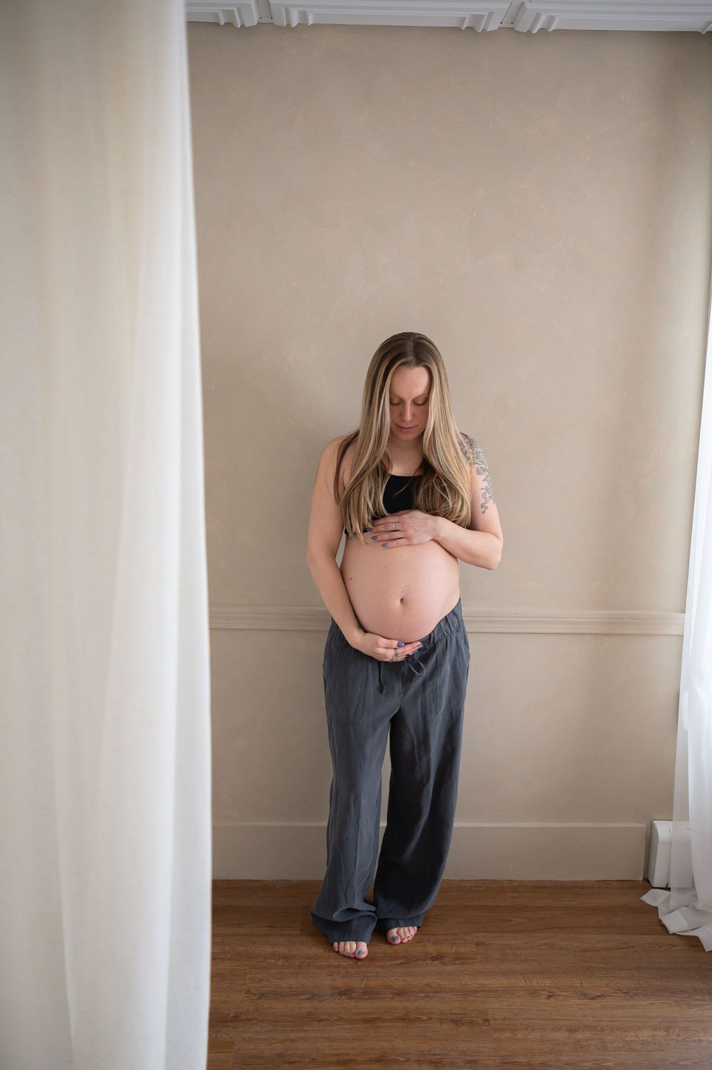 Three connected images show a person crouched in different positions against a white wall in an empty room with wooden floors.