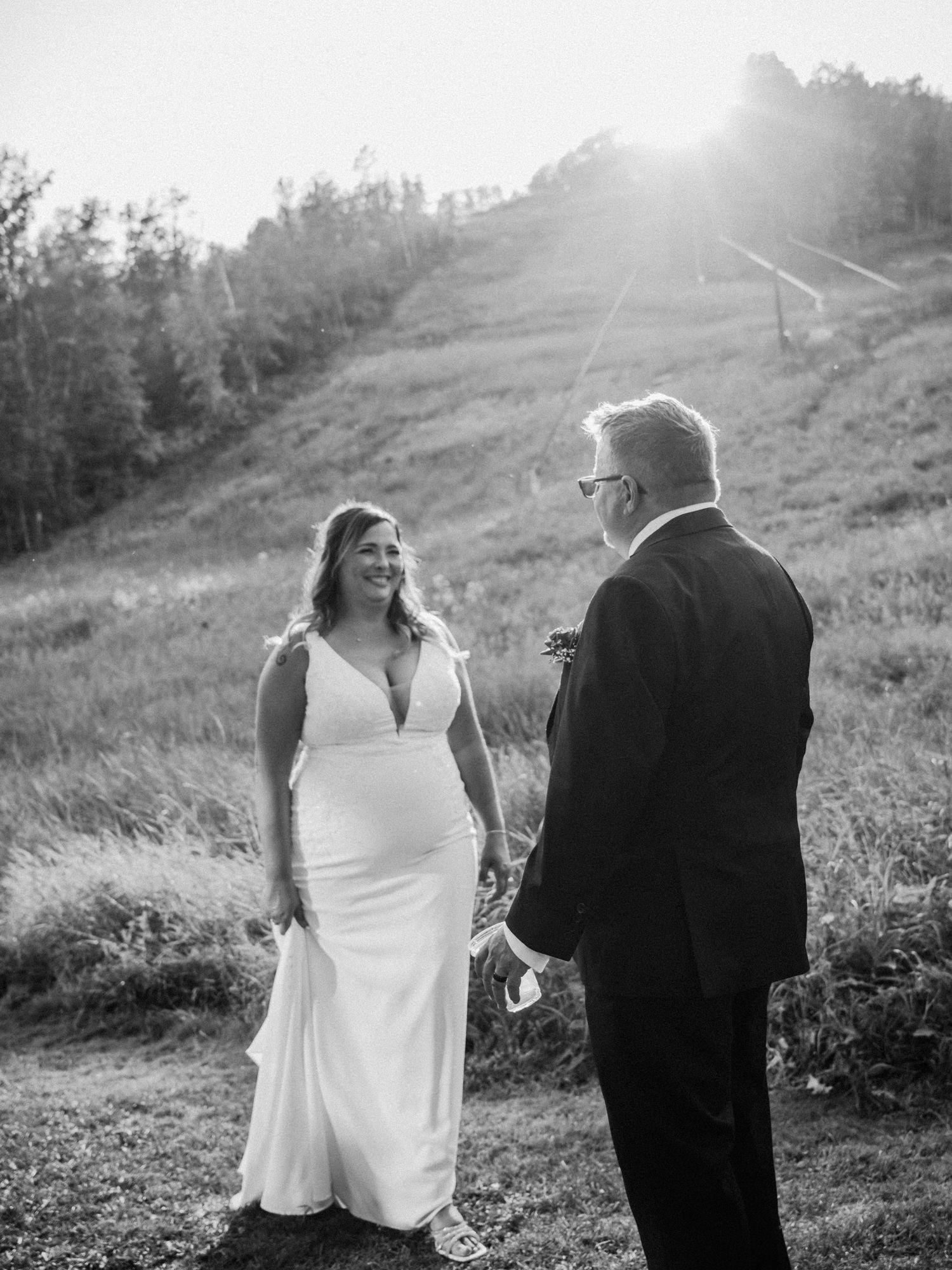 Black and white photo of wedding party dancing on beach with motion blur.