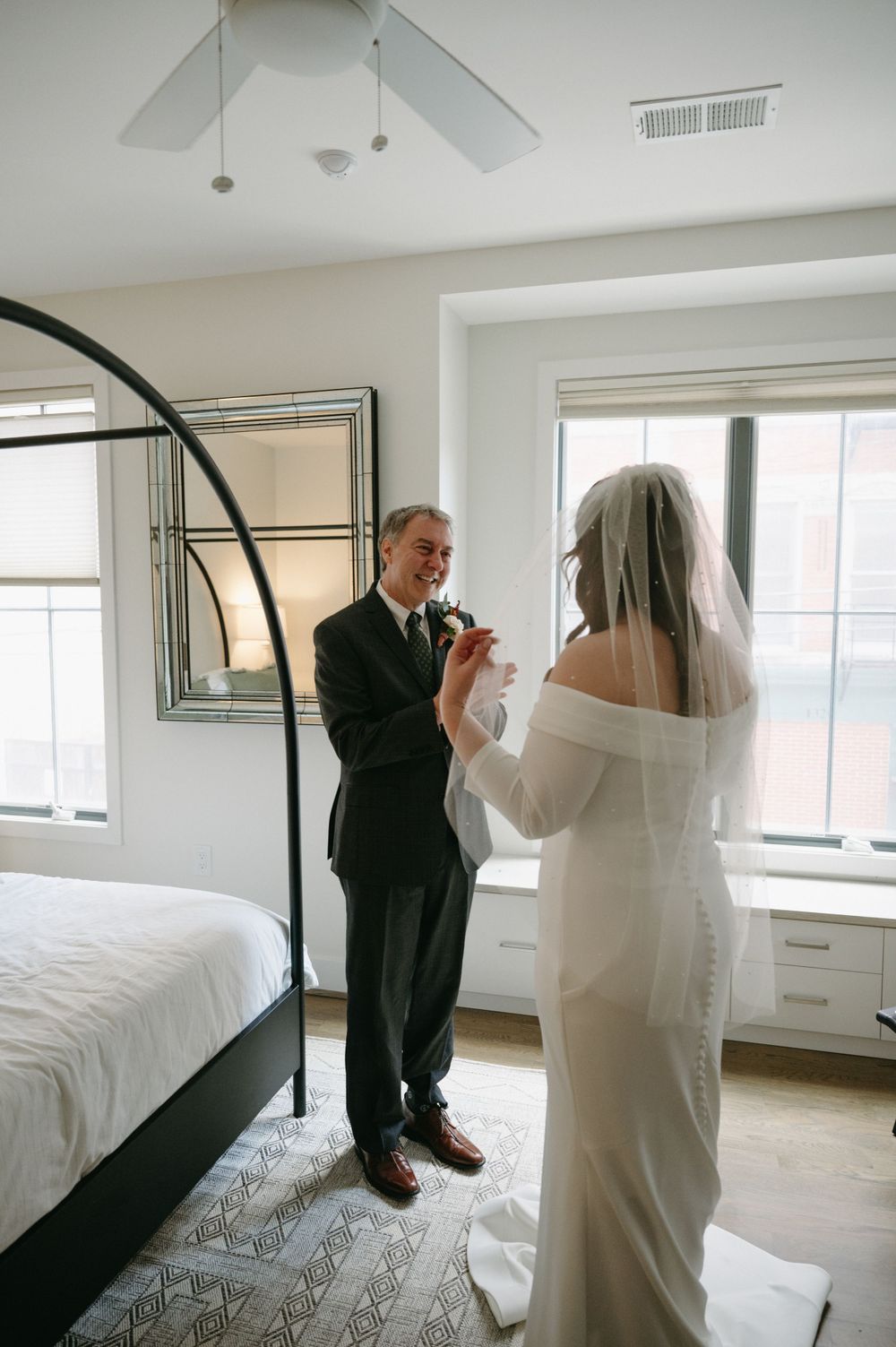 An emotional exchange between a couple during their wedding ceremony in a sunlit room.