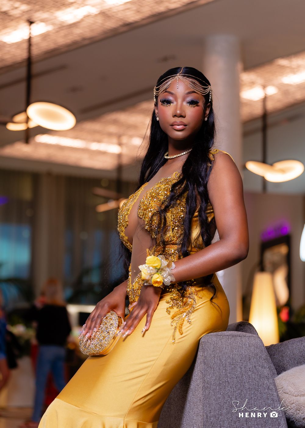 Elegant formal portrait in flowing gold gown with intricate beading and long straight hair.