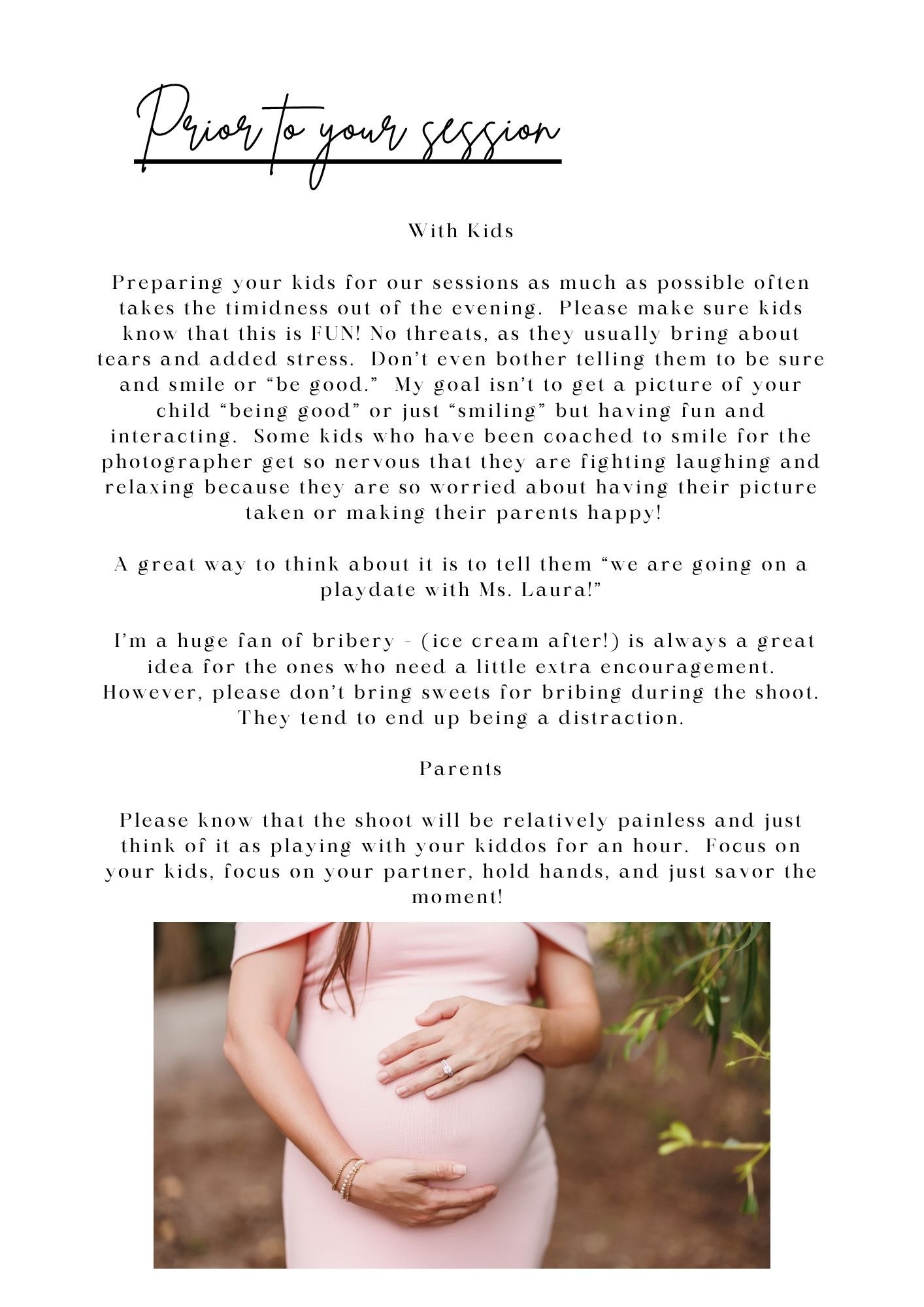 A pregnant woman in a white dress cradles her baby bump during a maternity photo session.