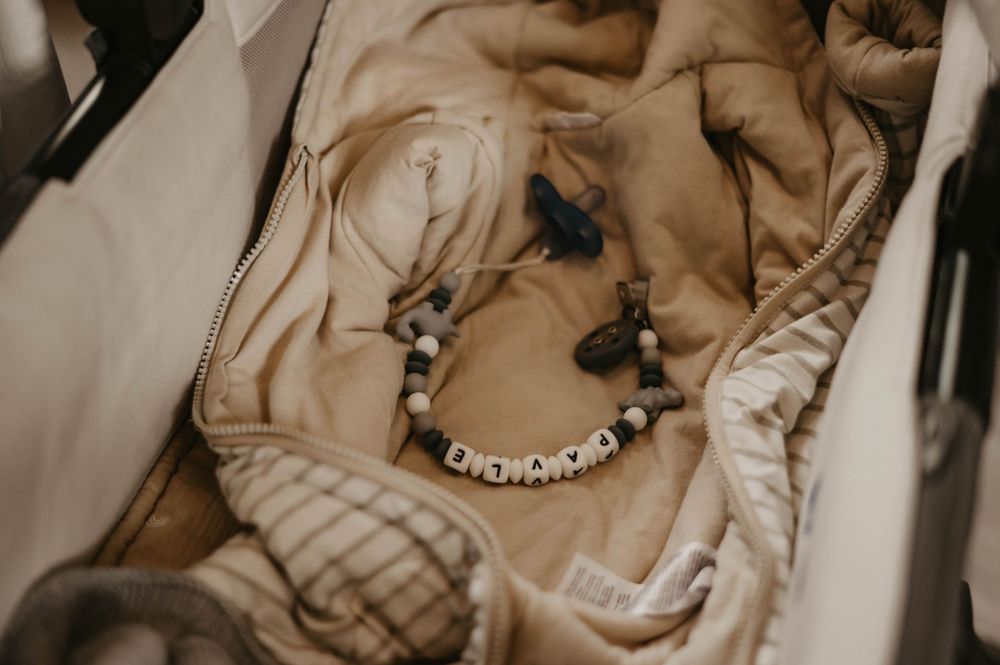 A beaded bracelet laying on crumpled beige fabric with delicate details in soft lighting.
