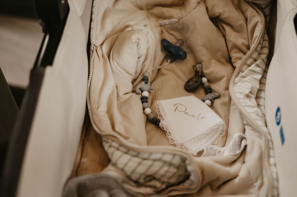 Beaded jewelry and decorative elements arranged on wrinkled fabric in muted tones.