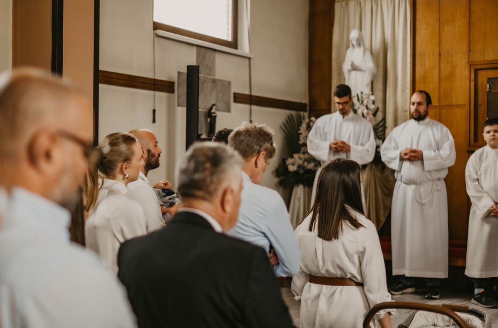 A congregation gathered in a church with wooden paneled walls for a religious service.