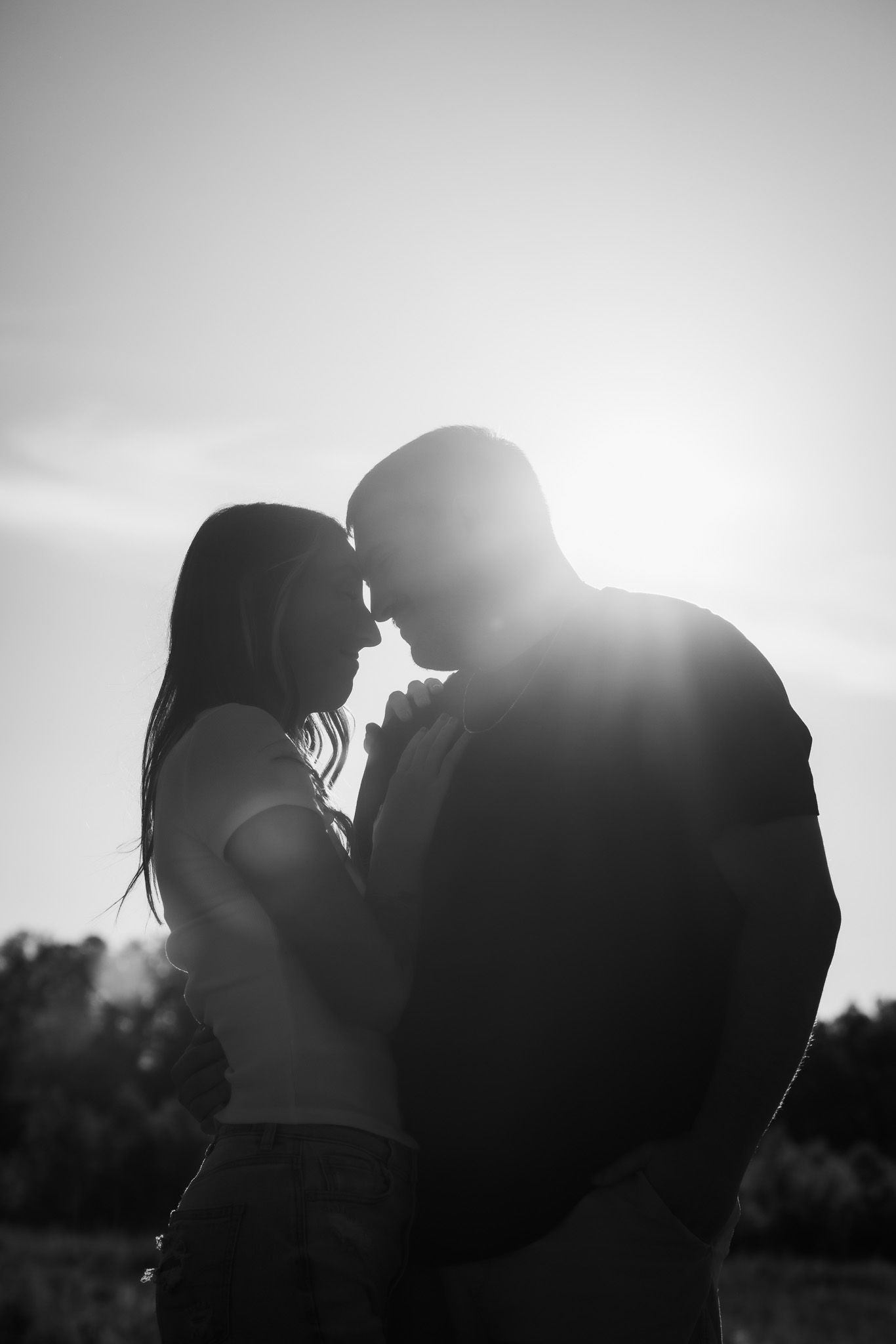 Silhouetted equestrian photography session against a bright backlit sky.