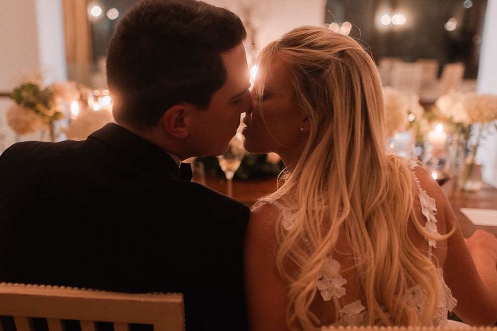 Romantic candlelit moment between newlyweds at their wedding reception.