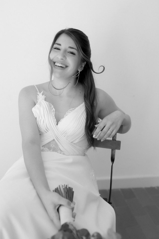 Black and white portrait of a joyful bride in a white dress.