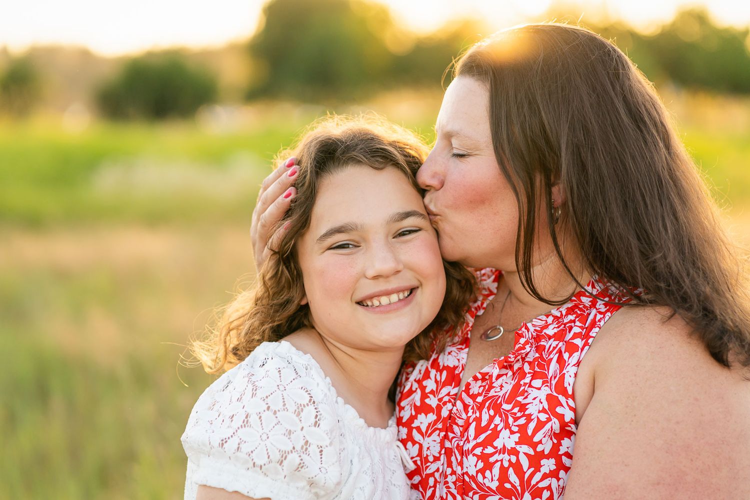 Mother kisses daughter at sunset in Redmond