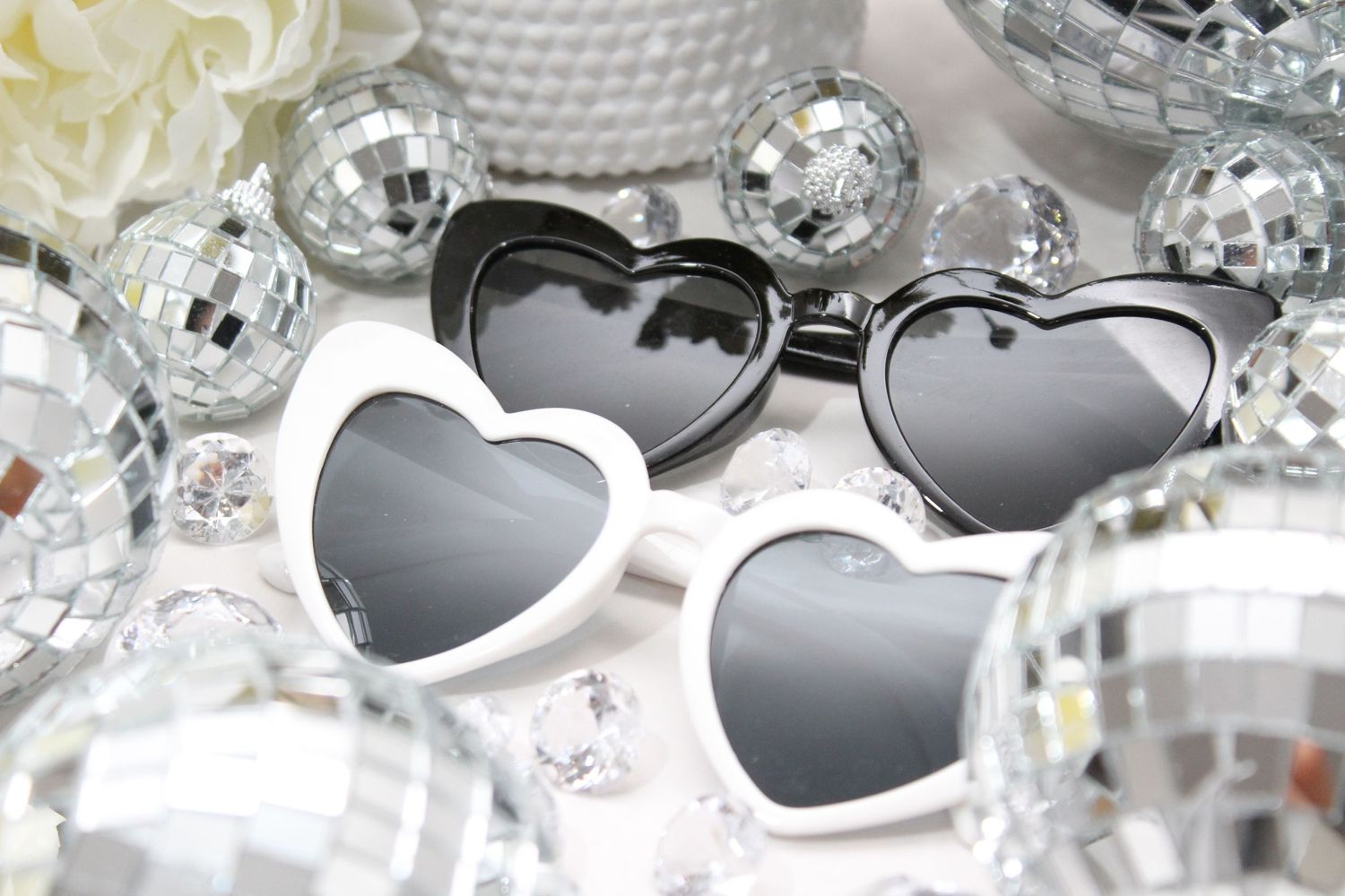 Heart-shaped sunglasses arranged with silver disco balls and decorative elements. Perth WA Photo booth Hire Event Booth