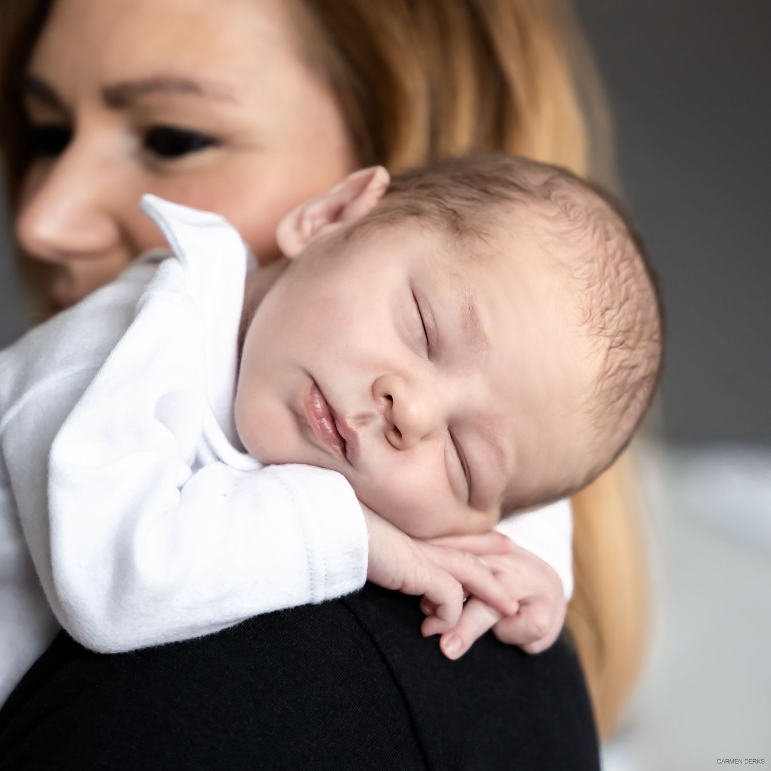 baby tijdens newbornshoot slapend op schouder van moeder
