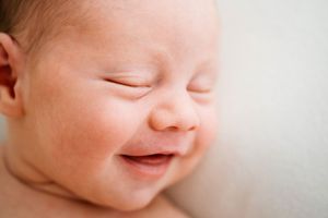 Gentle close-up of a newborn baby's smile and facial features.