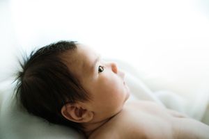 Peaceful sleeping newborn baby photographed in soft natural light.
