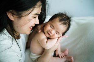Intimate mother and newborn bonding moment captured in soft lighting.