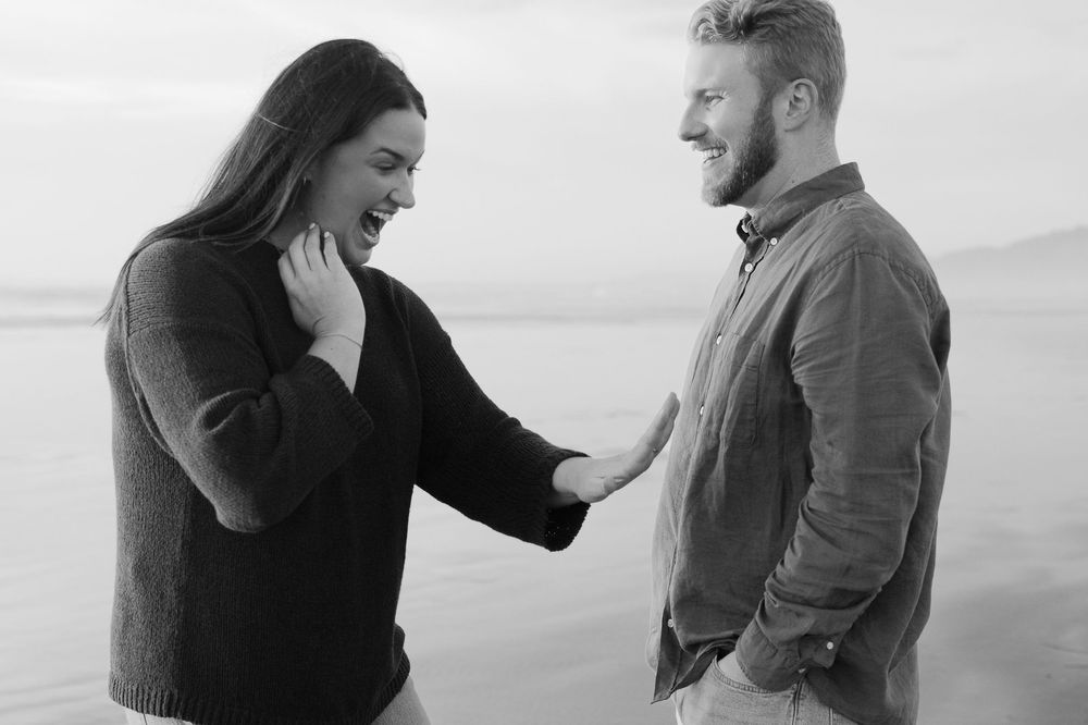 Emotional engagement moment captured in black and white against natural backdrop.