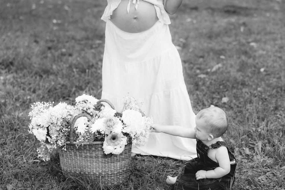 A series of black and white photos showing a child in a white dress playing in a garden with flowers and baskets.