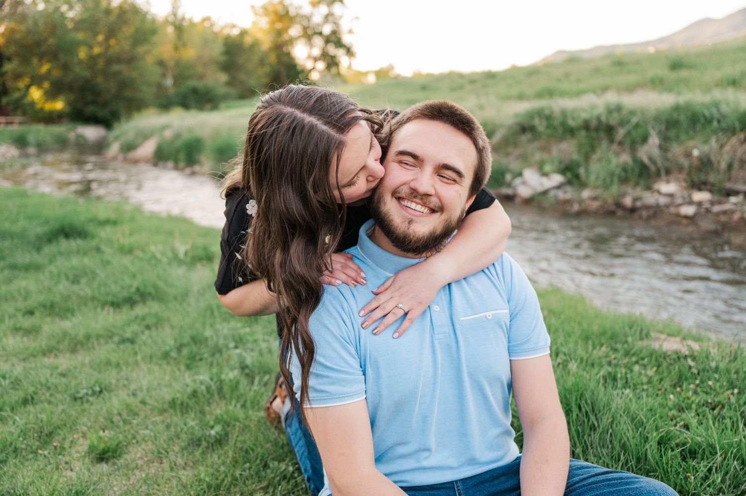 Affectionate moment captured between couple in light blue and dark clothing outdoors.
