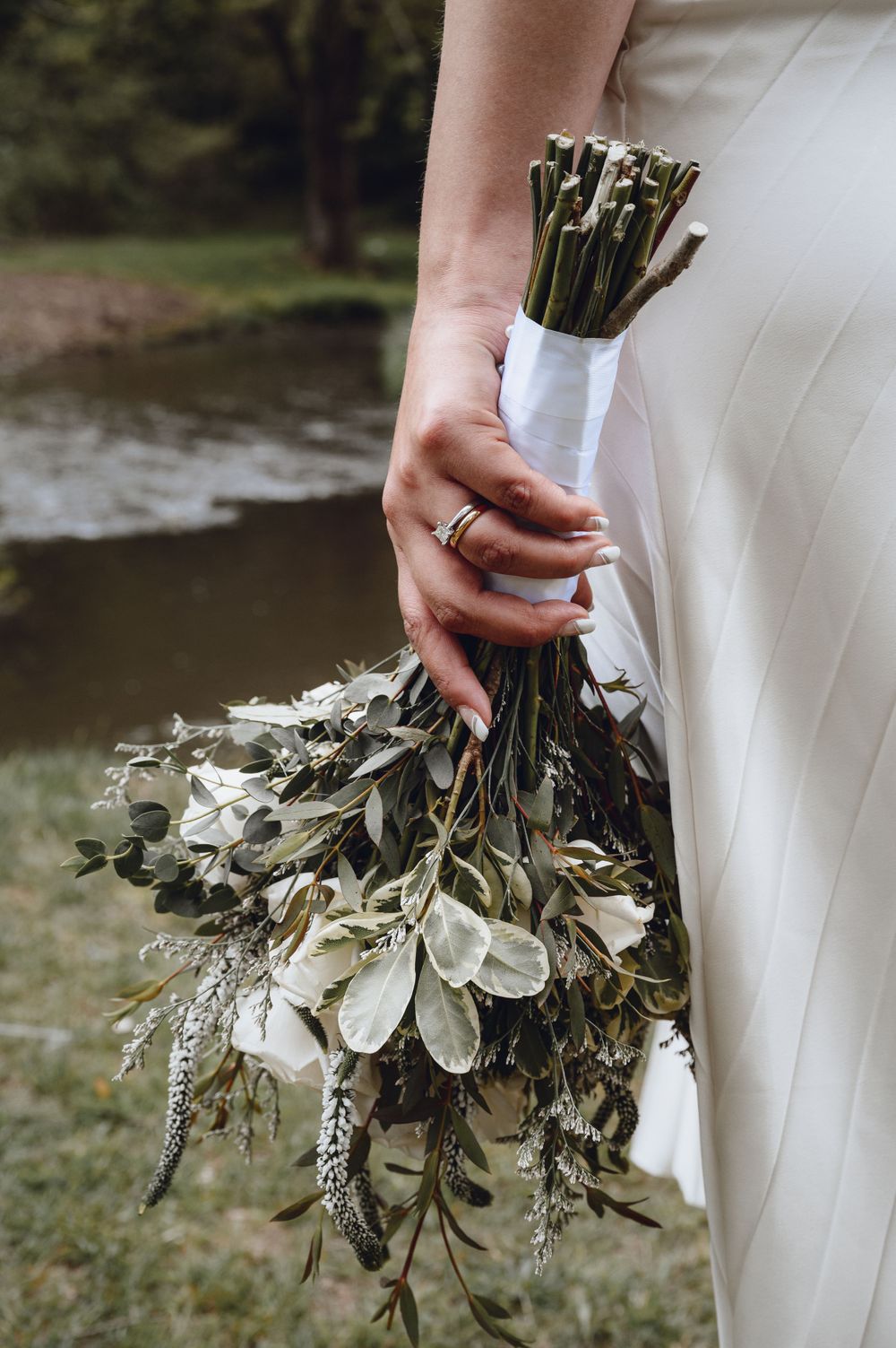 Close-up of elegant wedding bouquet with white flowers and greenery.