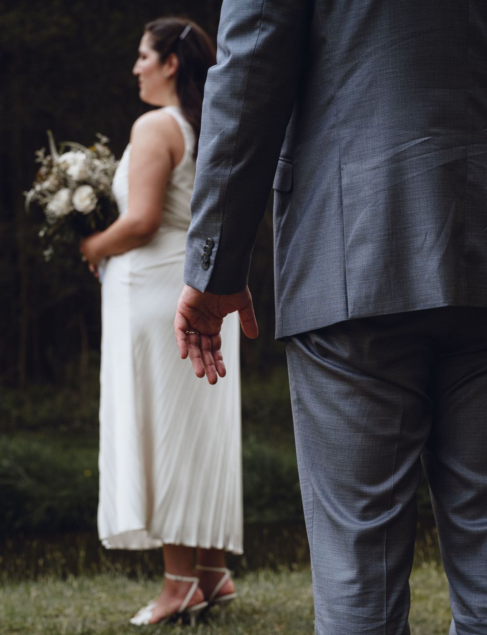 Detail shot of formal attire and dress during outdoor wedding.