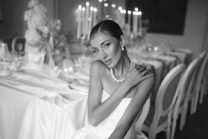 Black and white photo series of a bride at an elegant reception venue with candlelit tables and formal place settings.