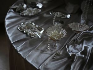 Close-up details of a wedding dress showing intricate beadwork, crystal embellishments, and delicate fabric textures.