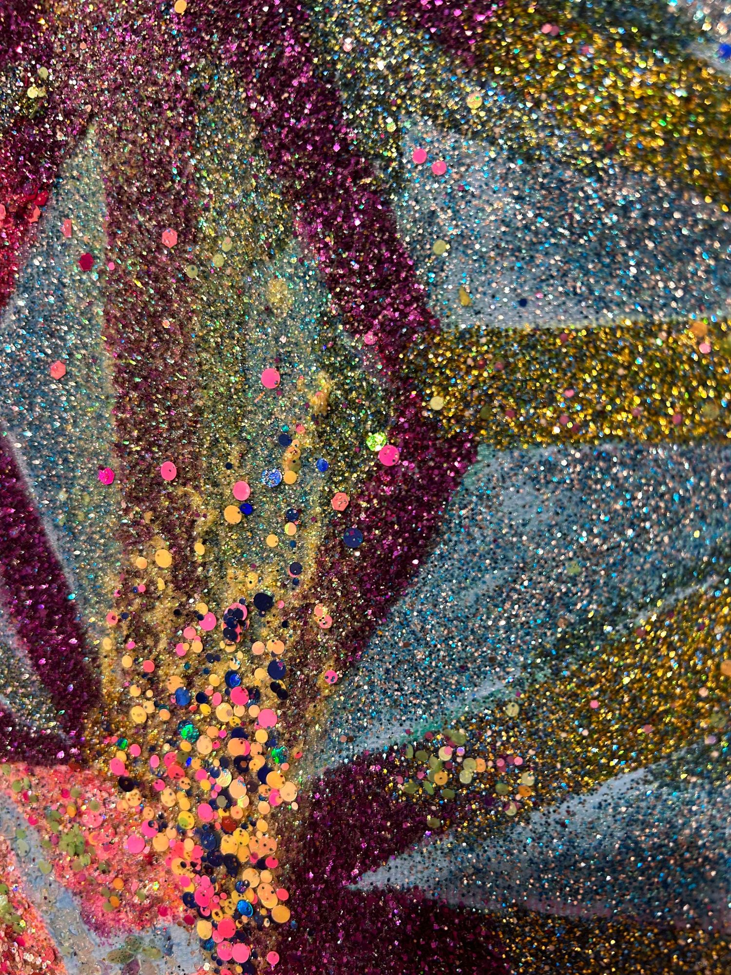 Close-up of glittery multicolored artwork showing purple, gold and blue sparkly textures.