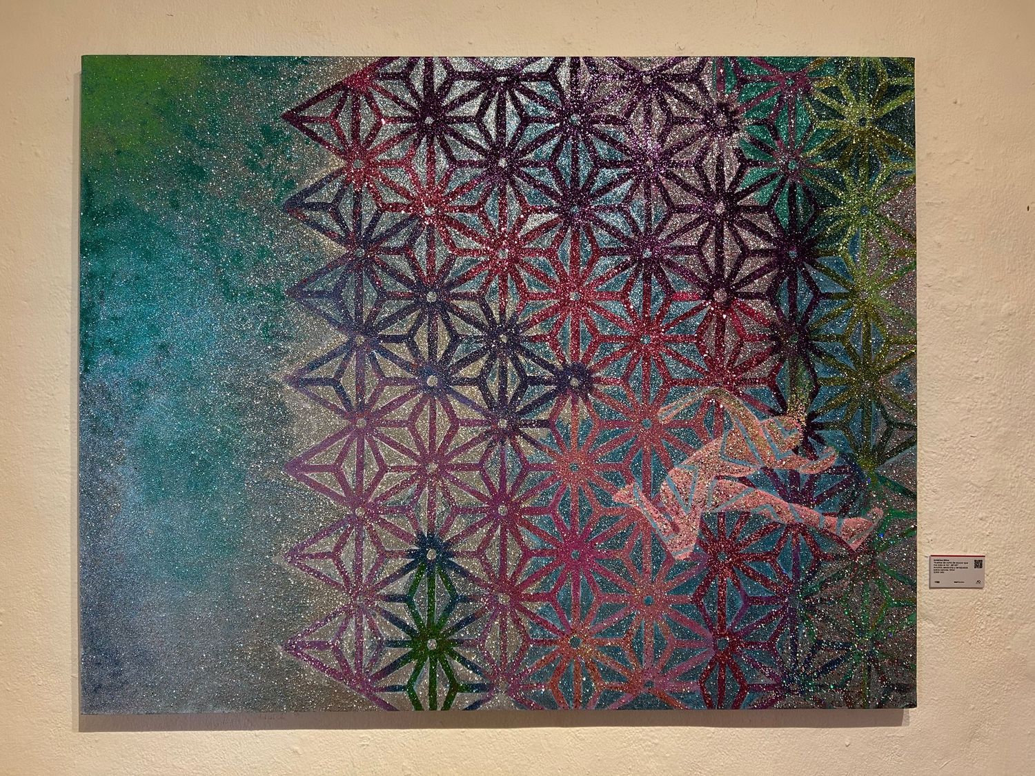 glitter artwork showing a silhouette against a geometric flower pattern on turquoise background.