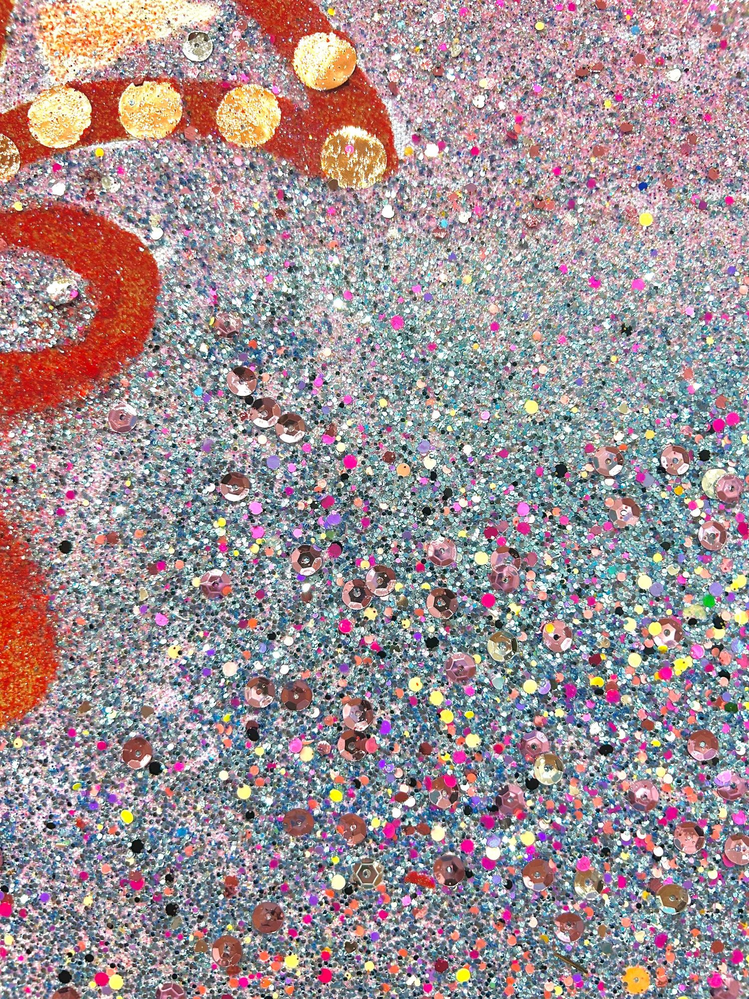 Abstract art detail showing red circular pattern with scattered iridescent glitter and sequins.